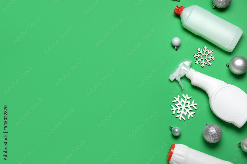 Bottles of detergent with Christmas balls and snowflakes on green background