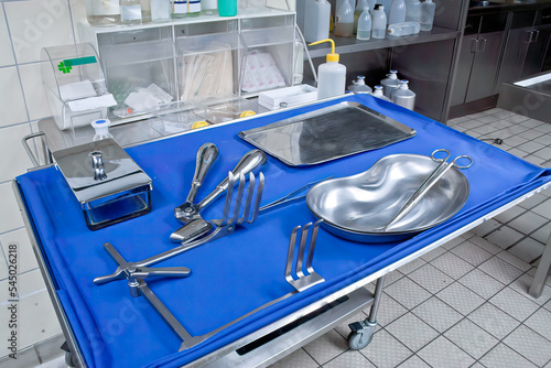 Surgical instruments and tools such as scalpels, forceps and tweezers are placed on the operating table. photo