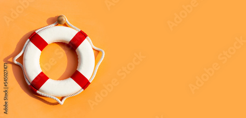 Lifebuoy on orange background. Copy space