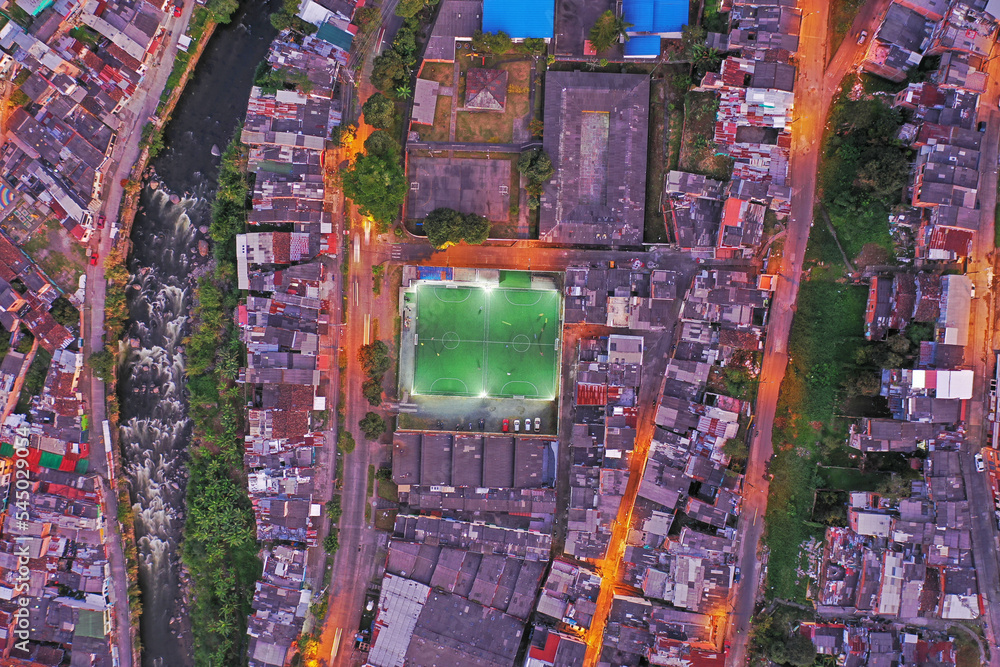 Obraz premium Pereira Risaralda Colombia. una captura cenital de una parte de la ciudad en un atardecer mostrando aun costado el río Otún y teniendo como centro la cancha de sintética. 