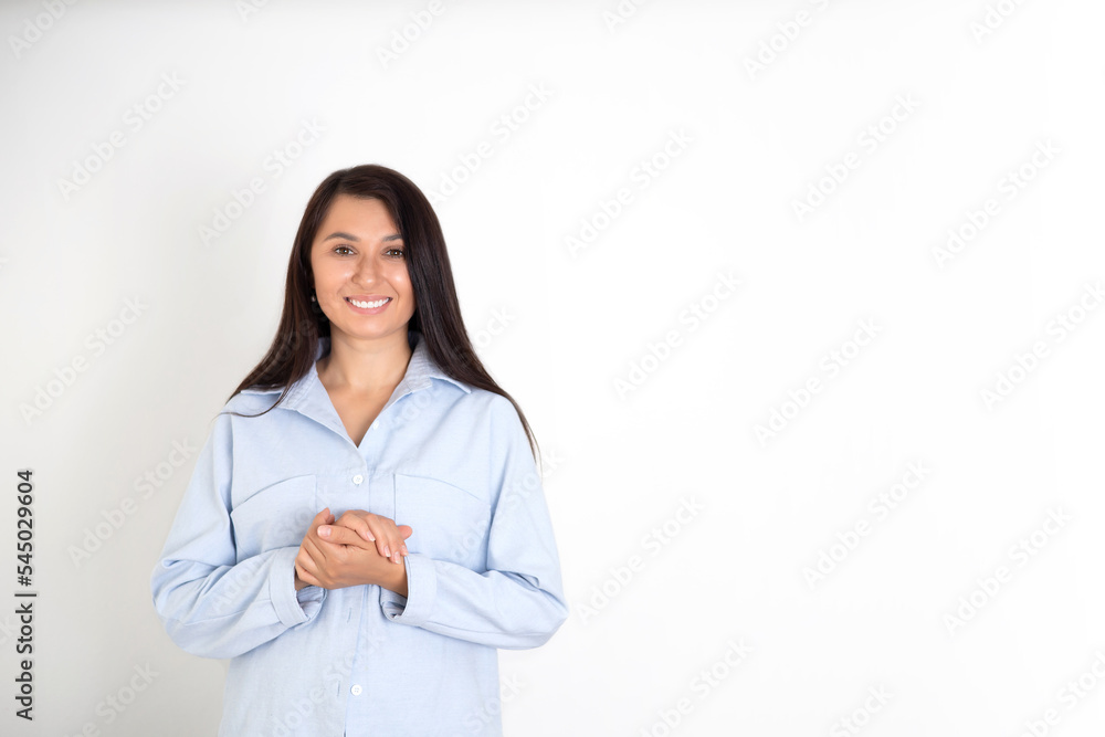 Portrait of a beautiful brunette woman in a blue shirt on a white background. Neutral makeup. Space for text Portrait of a beautiful brunette woman in a blue shirt on a white background. Neutral makeup. Space for text