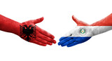 Handshake between Paraguay and Albania flags painted on hands, isolated transparent image.