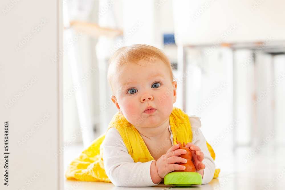 young australian baby girl in yellow dress playing with kangaroo toy on floor young australian baby girl in yellow dress playing with kangaroo toy on floor