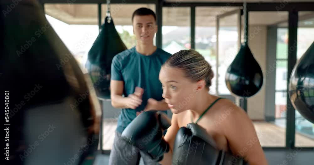 Fitness, boxing and woman learning from personal trainer self defense, fighting or punching exercises at gym. Motivational sports mentor coaching, training or teaching a healthy and strong girl boxer Fitness, boxing and woman learning from personal trainer self defense, fighting or punching exercises at gym. Motivational sports mentor coaching, training or teaching a healthy and strong girl boxer