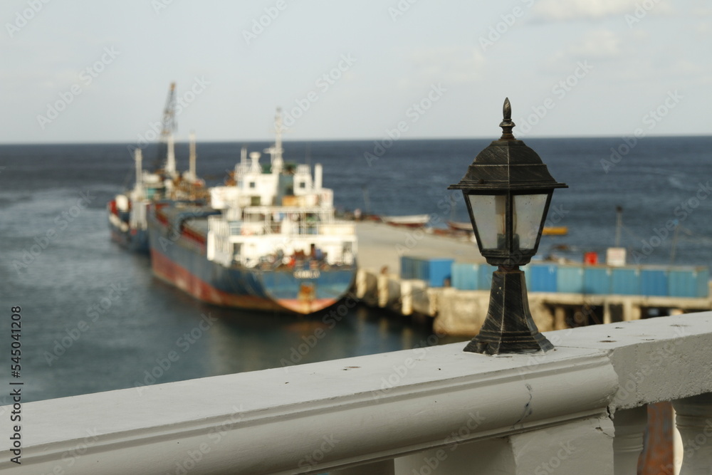 Antique lamp in foreground overlooking a small fishing port