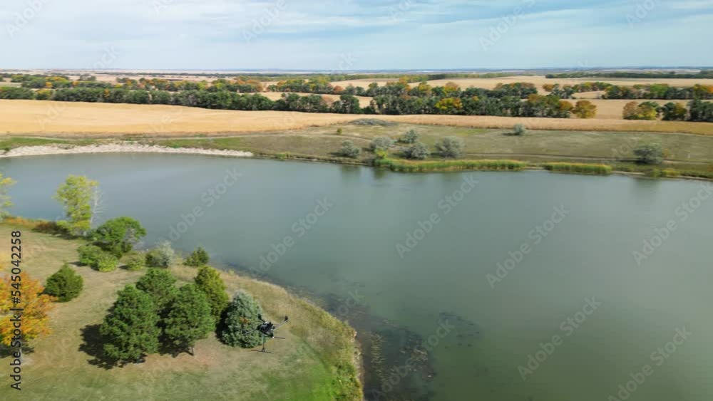 Aerial tracking shot of a large drone coming back in to land over a lake Aerial tracking shot of a large drone coming back in to land over a lake