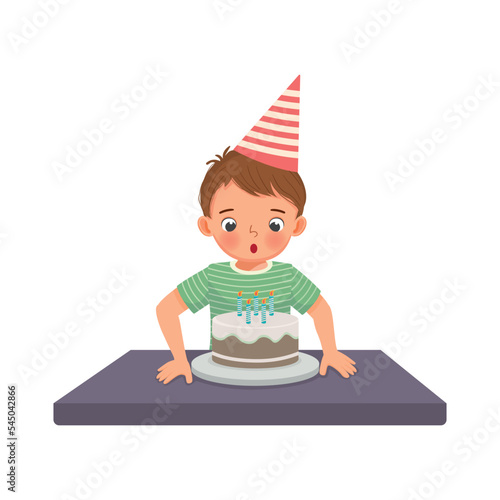 happy little boy blowing candles celebrating his birthday party