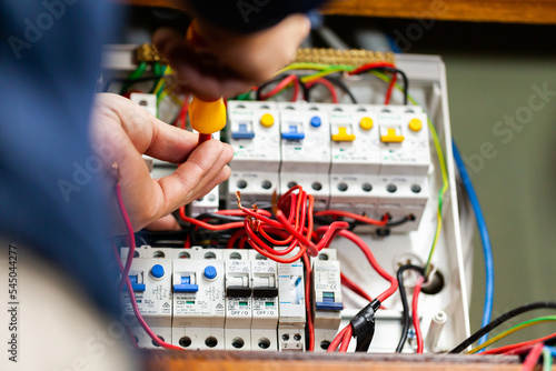 Electrician tradesman rewiring switch board for solar power