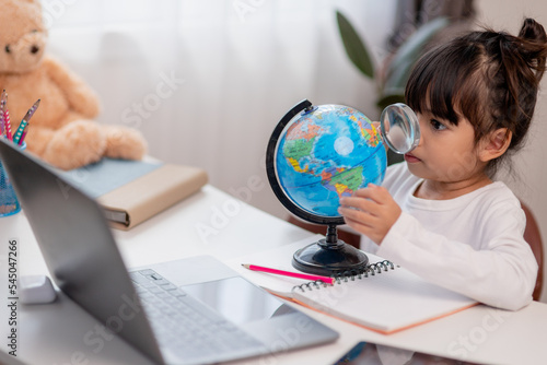 Asian little girl is learning the globe model, concept of save the world and learn through play activity for kid education at home.