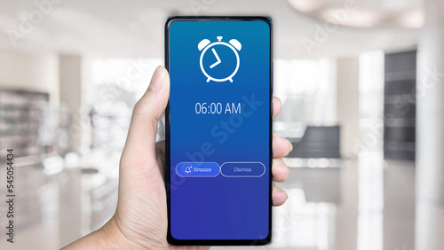 Good morning 6 am alarm clock on the phone, a finger taps dismiss. business, people and future technology concept 
