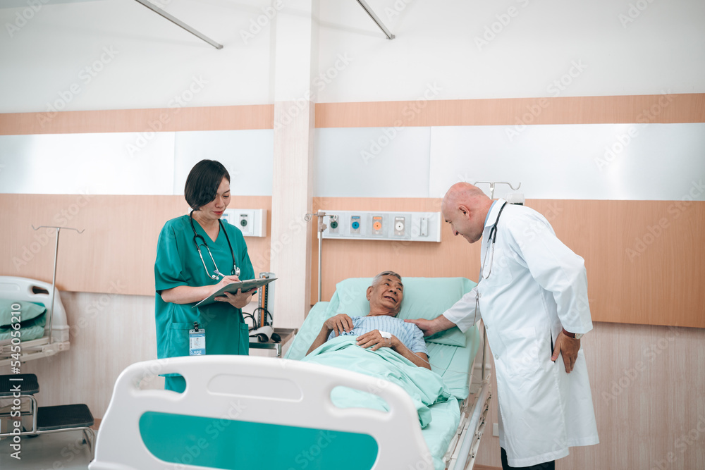 Obraz premium professional doctor standing by explain the treatment information via male elderly patient lying in bed in private hospital sickroom. The treatment program is suitable for people to socialize elderly