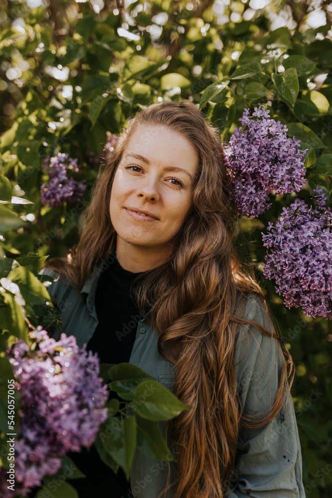 Portrait of smiling woman standing against lilac bush Portrait of smiling woman standing against lilac bush