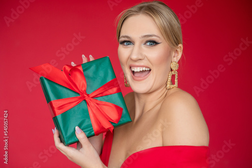 Surprised, grateful, elegant blond woman laughing with open mouth and look at camera, receive green and red present box