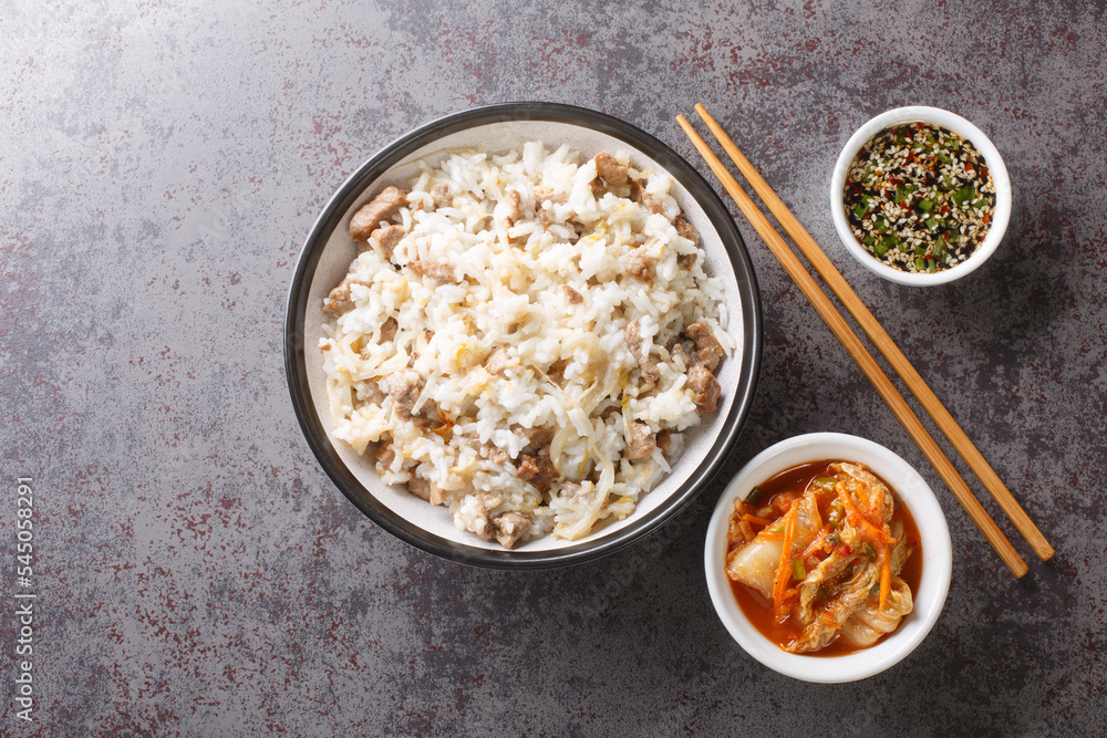 Easy and delicious Korean soybean sprout rice Kongnamul Bap with yummy seasoned soy sauce and kimchi closeup on the table. Horizontal top view from above Easy and delicious Korean soybean sprout rice Kongnamul Bap with yummy seasoned soy sauce and kimchi closeup on the table. Horizontal top view from above