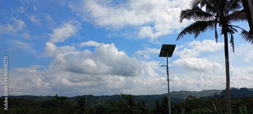 Solar cell panels on hill landscape against sky background