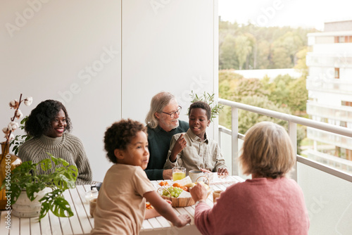 Family sitting at table on balcony photo