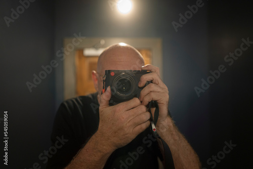 bold man with a leica camera in mirror photo