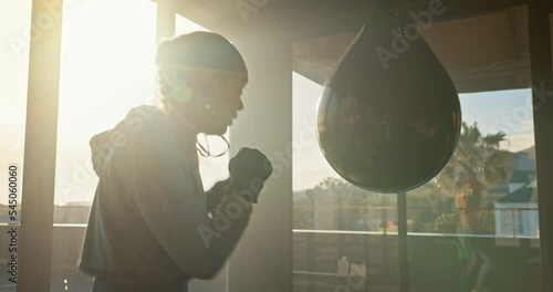 Fitness, woman and fighter boxing bag in sports training, workout or exercise for competition at the gym. Active female boxer throwing punches on punching bag in competitive sport practice for match