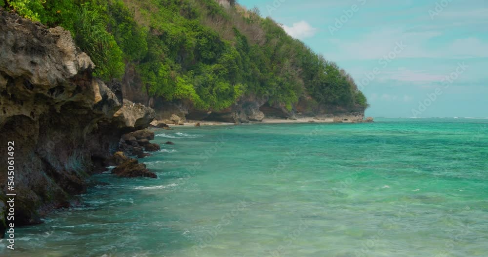 Green Bowl Beach in Bali. Waves splash and crash on rocky shore. Popular surf spot in Indonesia with white sand and crystal clear turquoise ocean water. Static shot. Green Bowl Beach in Bali. Waves splash and crash on rocky shore. Popular surf spot in Indonesia with white sand and crystal clear turquoise ocean water. Static shot.
