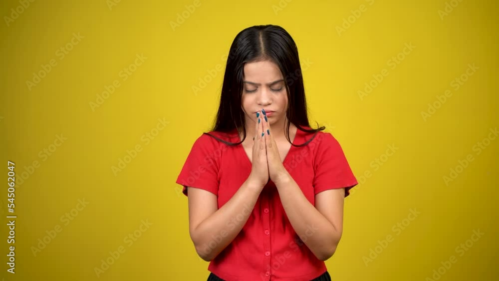 Young worried girl standing with fingers crossed for good luck isolated over yellow background Young worried girl standing with fingers crossed for good luck isolated over yellow background