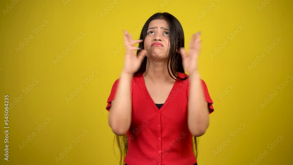 Young worried girl standing with fingers crossed for good luck isolated over yellow background Young worried girl standing with fingers crossed for good luck isolated over yellow background