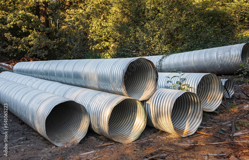 Stormwater pipes. Large Corrugated Metal Culvert Pipes in Field. Flexible corrugated aluminum tubes photo