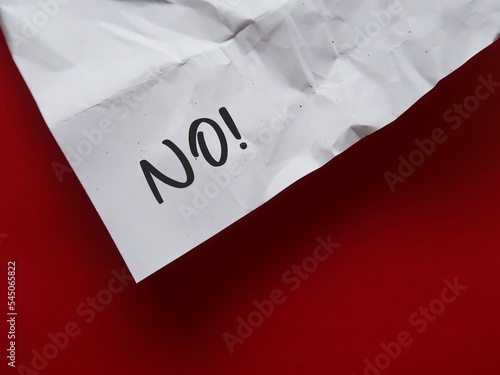 Crumpled paper with handwritten text NO on red background, concept of learning to say no without feeling guilty , stop people pleasing, create personal boundaries for yourself based on what you want