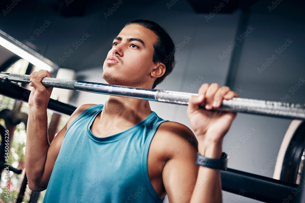 Fitness, man and weightlifting barbell at the gym for heavy workout, training or intense sports exercise. Male body builder lifting weights for strength, muscle and endurance for strong arms indoors Fitness, man and weightlifting barbell at the gym for heavy workout, training or intense sports exercise. Male body builder lifting weights for strength, muscle and endurance for strong arms indoors