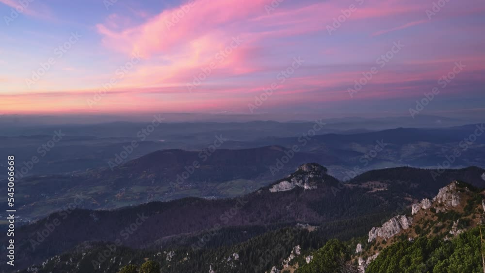 Warm colors of clouds at dusk in a rocky forest mountain landscape.Zoom in Warm colors of clouds at dusk in a rocky forest mountain landscape.Zoom in