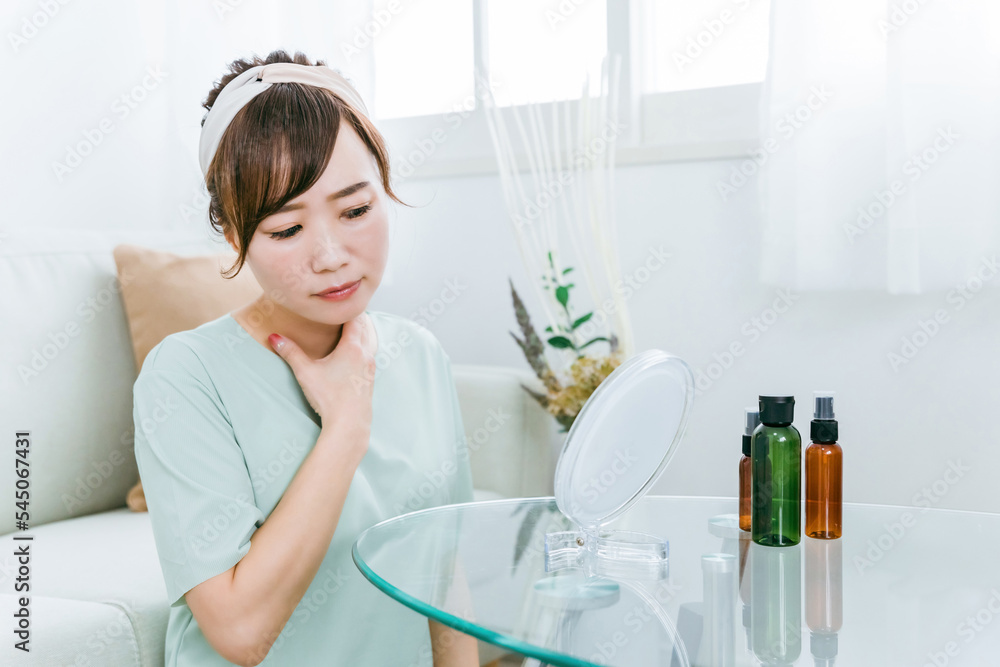 Fototapeta premium 鏡を見ながらスキンケアするアジア人女性（首） 