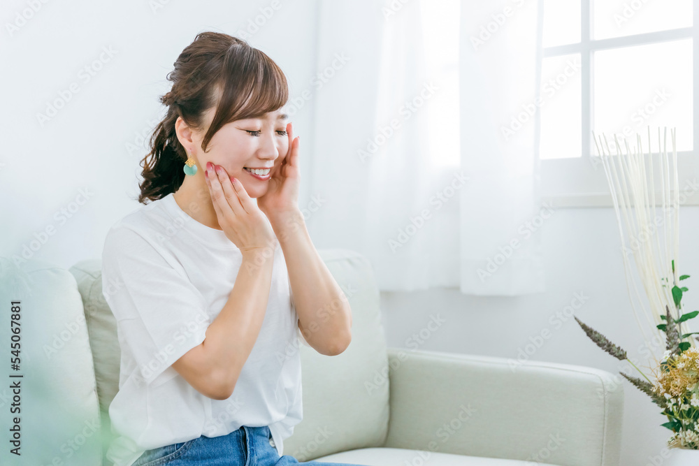 ソファに座りながらスキンケアのホームケアをする日本人女性
ソファに座りながらスキンケアのホームケアをする日本人女性