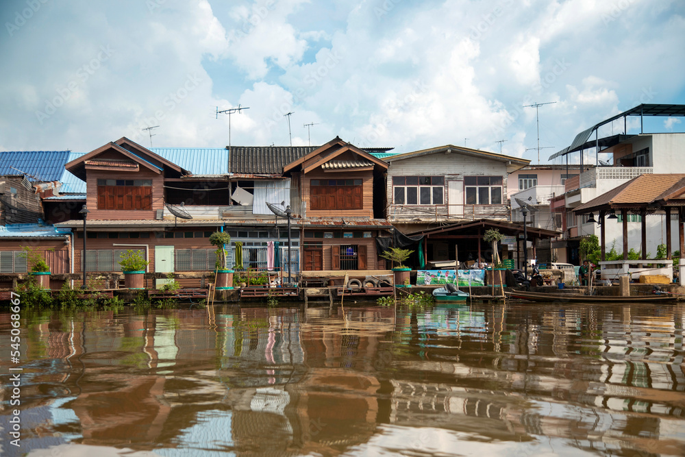Fototapeta premium Living riverside with palm tree in countryside of Thailand.