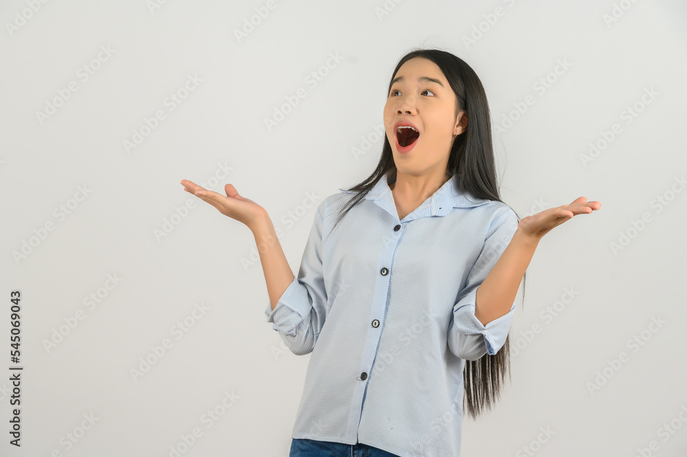 Portrait of Excited young asian woman in blue shirt hands up isolated on white background Portrait of Excited young asian woman in blue shirt hands up isolated on white background