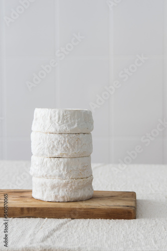 Stack of round wheels brie or camambert cheese on a white background, selective focus, copy space