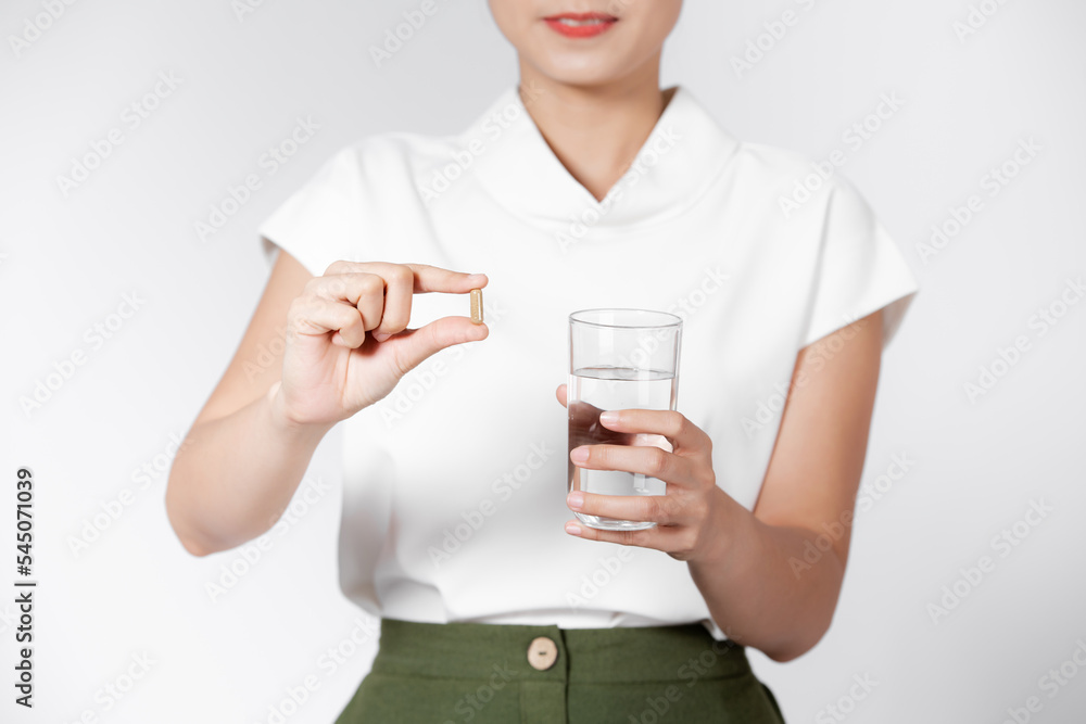 Pretty woman taking white pill on white background Pretty woman taking white pill on white background