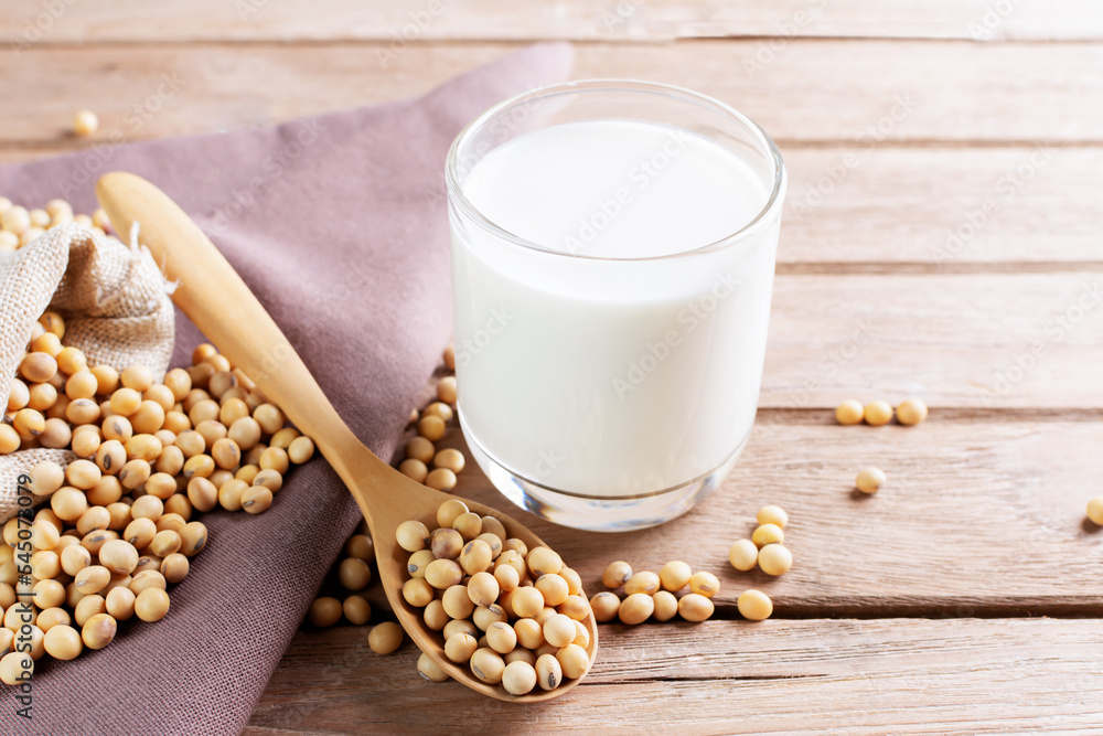 Soy milk in a glass with soybeans on a wooden table Organic breakfast, high protein, healthy, agricultural products, vegetarian Soy milk in a glass with soybeans on a wooden table Organic breakfast, high protein, healthy, agricultural products, vegetarian