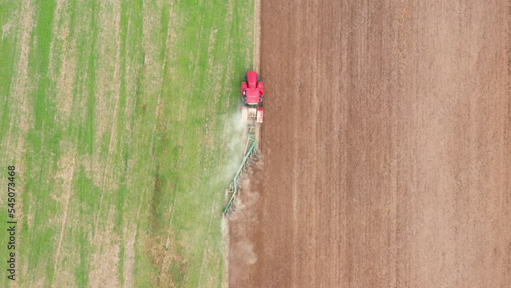 Agricultural work in field in spring and autumn. A rural worker rides tractor machine with plow attached and plowing ground before planting new crop or after harvesting. Aerial top view in movement Agricultural work in field in spring and autumn. A rural worker rides tractor machine with plow attached and plowing ground before planting new crop or after harvesting. Aerial top view in movement