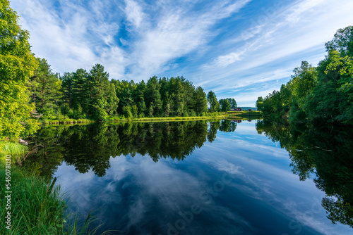 Beautiful summer view from the shore of a calm and shiny river