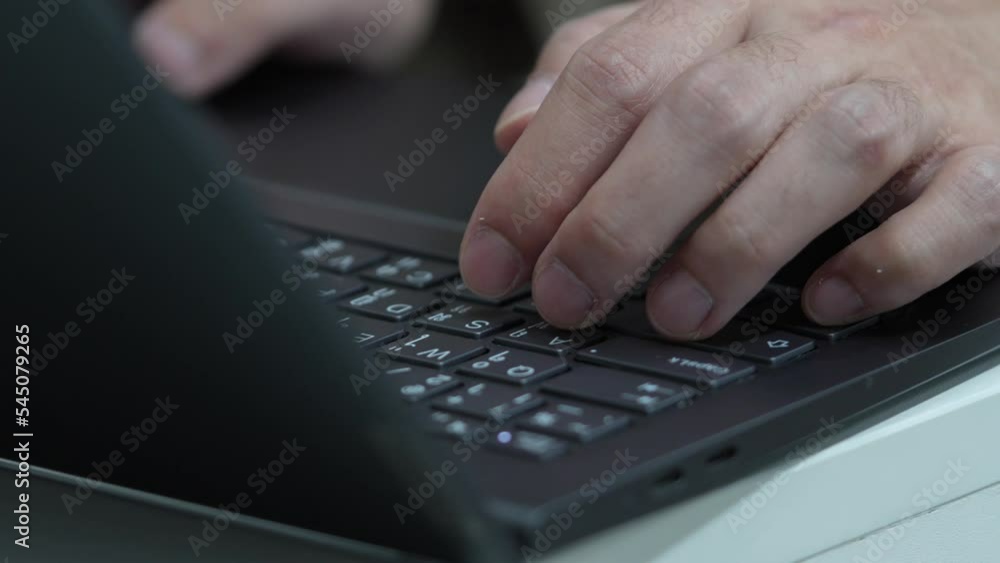 A man is typing on a black laptop provided with Thai English keyboard. A man is typing on a black laptop provided with Thai English keyboard.