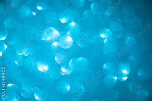 Shiny light blue blurred background for holiday design. Christmas abstract textured glitter, selective focus