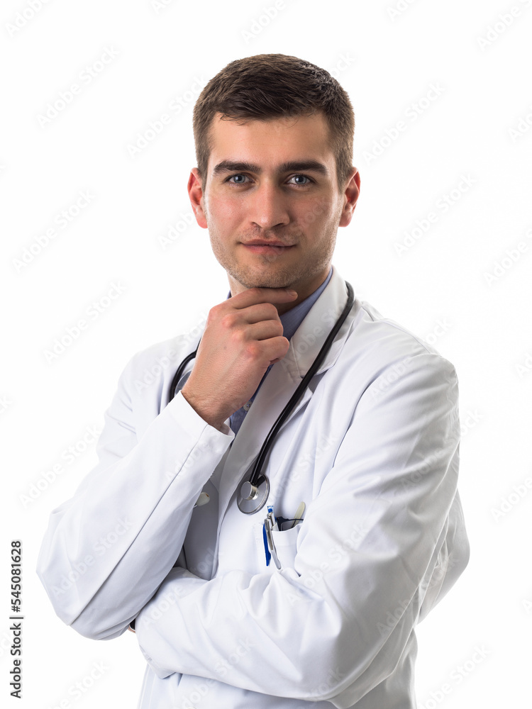 Portrait of hero in white coat. Cheerful smiling young doctor with stethoscope in medical hospital standing against white background. Coronavirus covid-19 danger alert Portrait of hero in white coat. Cheerful smiling young doctor with stethoscope in medical hospital standing against white background. Coronavirus covid-19 danger alert