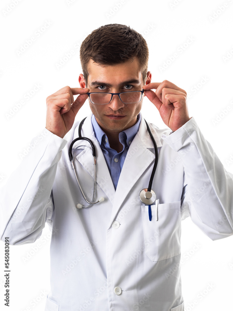 Confident male doctor in white lab coat and stethoscope standing with folded arms smiling at the camera isolated on white Confident male doctor in white lab coat and stethoscope standing with folded arms smiling at the camera isolated on white
