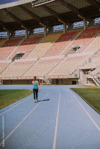 Girl walking on a blue sports track