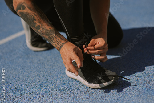 A male sportsperson lacing his sneakers