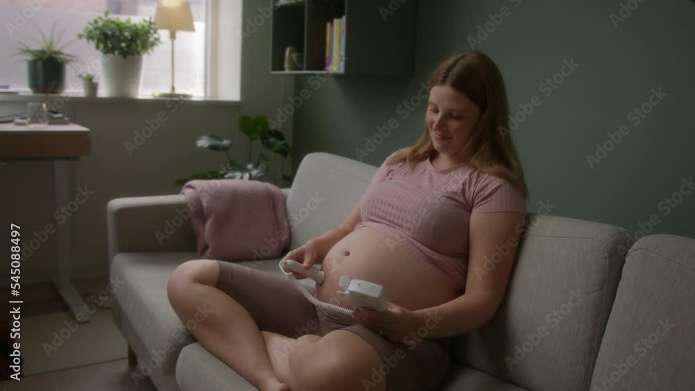 Pregnant Woman Sitting While Using A Doptone Pregnant Woman Sitting While Using A Doptone
