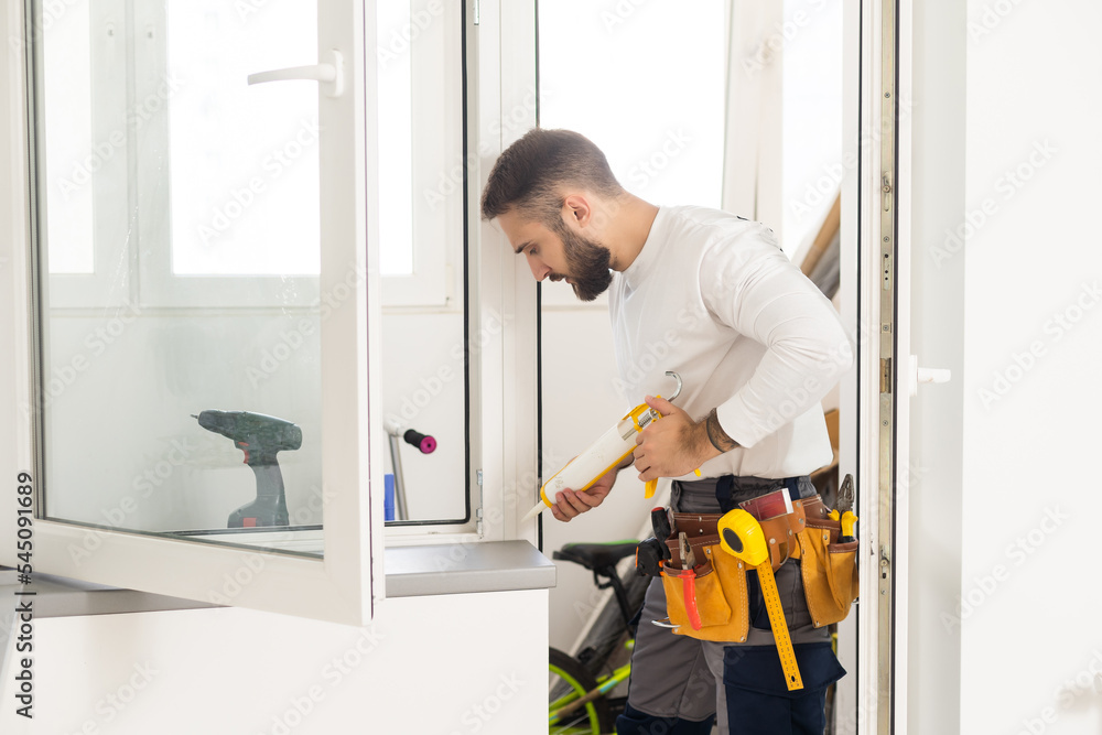 Fototapeta premium service man installing window with screwdriver