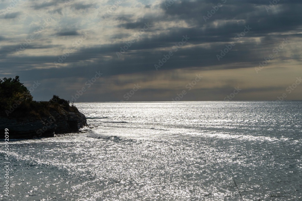 White waves break on rocky coast of the Black Sea in Gelendzhik. White splashes and foam in foreground. Emerald blue sea water. September Sea at the southern resort of Russia.