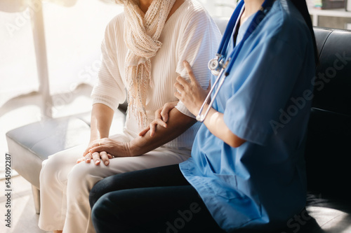 Close up view of old woman leaning on nurse while siting.