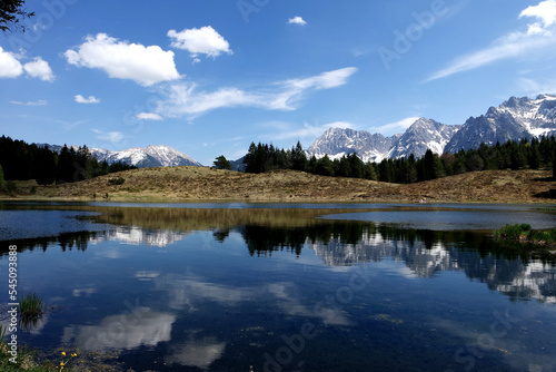 Fototapeta Naklejka Na Ścianę i Meble -  Alp mountains reflecting at a lonesome lake with blue cloudy sky