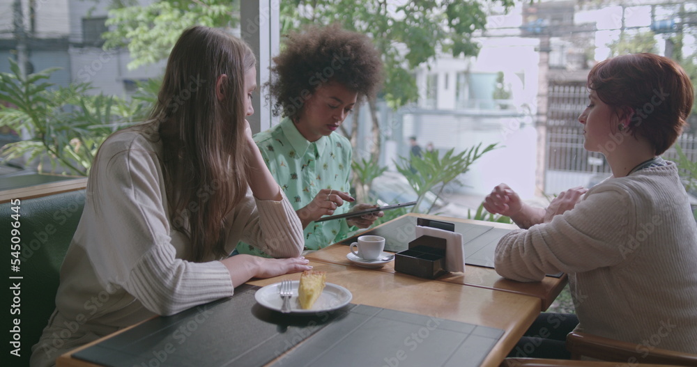 Group of women speaking at cafe restaurant. Three friends talking together at coffee shop Group of women speaking at cafe restaurant. Three friends talking together at coffee shop